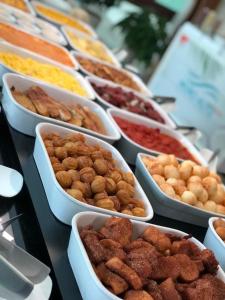 ein Buffet mit verschiedenen Speisen in weißen Schüsseln in der Unterkunft Porto de Galinhas Resort Marulhos in Porto De Galinhas