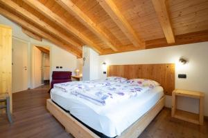 1 dormitorio con 1 cama grande y techo de madera en Garnì dal Mozat, en Ledro