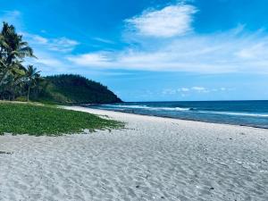 una spiaggia bianca con palme e l'oceano di Plumeria holidays a Saint-Pierre