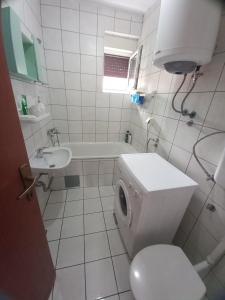 a white bathroom with a toilet and a sink at Apartman Ana in Trebinje
