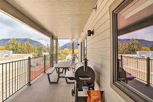 a balcony with a table and chairs and mountains at Cozy Columbia Falls Condo with Private Balcony! in Columbia Falls