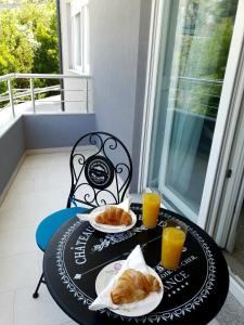 une table avec deux assiettes de nourriture et de jus d'orange dans l'établissement Orchid SeaView Apartment With Garage Parking, à Zaton