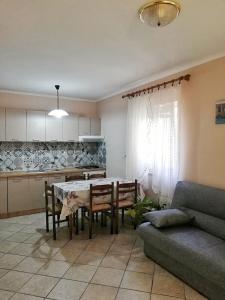 cocina y comedor con mesa y sofá en Apartments Jakšić en Supetar