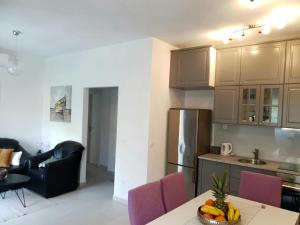 een keuken en een woonkamer met een tafel en stoelen bij Orchid SeaView Apartment With Garage Parking in Zaton