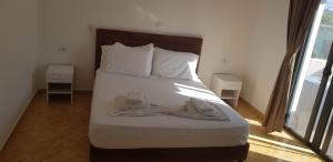 una cama con un par de zapatos sentados en ella en Apartments Villa Dovinefa, en Ksamil