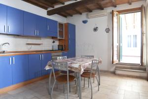 a kitchen with blue cabinets and a table with chairs at Appartamenti LEVANTE e LIBECCIO in Follonica