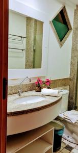 ein Badezimmer mit Waschbecken und Spiegel in der Unterkunft Porto de Galinhas Resort Marulhos in Porto De Galinhas
