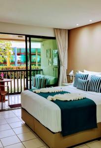 ein Schlafzimmer mit zwei Betten und einem Balkon in der Unterkunft Porto de Galinhas Resort Marulhos in Porto De Galinhas