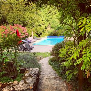 una piscina en un jardín con árboles y flores en Uniquely Private Holiday Villa in the Charente en Puyréaux