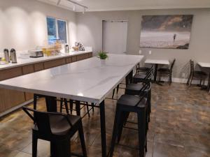 a large kitchen with a large white table and chairs at SureStay Hotel by Best Western Chula Vista San Diego Bay in Chula Vista