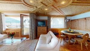 a living room with a white couch and a table at Paravicini 1 in St. Moritz