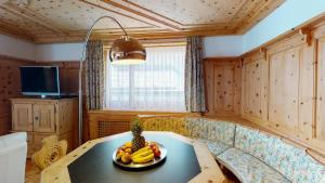 a room with a table with a bowl of fruit on it at Paravicini 1 in St. Moritz