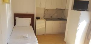 um pequeno quarto com uma cama e um lavatório em Apartments Villa Dovinefa em Ksamil