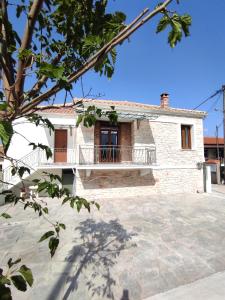 una casa in mattoni con balcone di fronte di Habezeiko - The Vintage House ad Áfitos