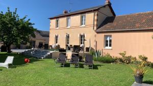 um grupo de cadeiras sentadas no pátio de uma casa em VILLA CATHY Chambres d hôtes em Dives-sur-Mer
