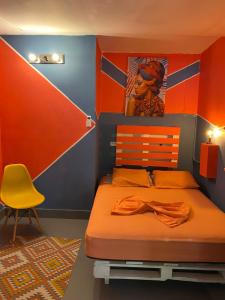 1 dormitorio con 1 cama y 1 silla amarilla en Zebulo Hostel, en Panamá