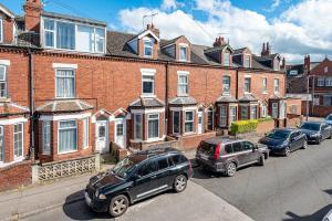 a row of cars parked in front of brick houses at Kingsway Property in Goole