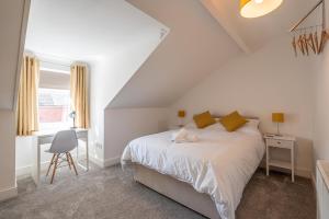 a white bedroom with a bed and a desk at Kingsway Property in Goole