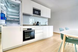 a kitchen with white cabinets and a table at Alse Homes Adeje Mountain in Adeje