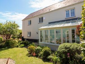 a large white house with a conservatory at Home Farm Cottage in Barnstaple
