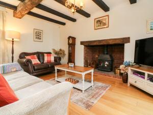 uma sala de estar com um sofá e uma lareira em Home Farm Cottage em Barnstaple