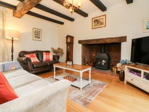a living room with a couch and a fireplace at Home Farm Cottage in Barnstaple