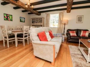 uma sala de estar com um sofá e uma mesa em Home Farm Cottage em Barnstaple