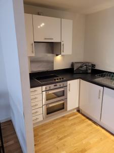 a kitchen with white cabinets and a stove top oven at Kew House in London