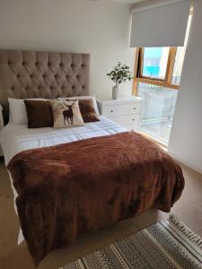 a bedroom with a large bed with a brown blanket at Kew House in London