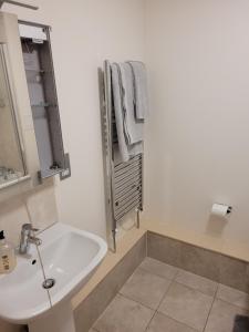 a white bathroom with a sink and a mirror at Kew House in London