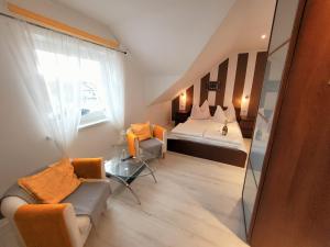 a small room with a bed and two chairs at IWONA Pokoje Apartamenty in Karwia