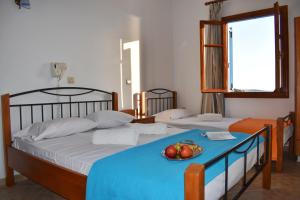 duas camas num quarto com uma tigela de fruta na cama em Amodari studios on the beach em Plaka