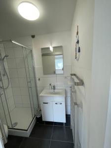 een badkamer met een wastafel en een douche bij Ferienwohnung Dünengras in Graal-Müritz