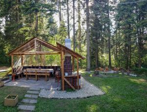 a wooden gazebo with a table in a yard at Guest Rooms- KLEPALSKI House in Borovets
