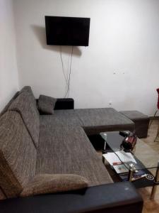 ein Wohnzimmer mit einem Sofa und einem Flachbild-TV in der Unterkunft Lara in Doboj