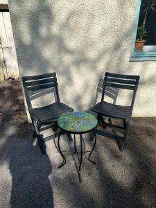 due sedie e un tavolo seduti accanto a un edificio di Jack’s Roost a Clovenfords