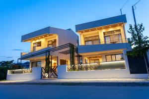 a large building with lights on in front of it at aella apartments in Nikiti