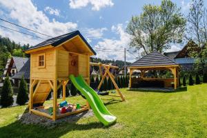 um parque infantil com uma casa de brincar e um escorrega em U Tatarów em Suche