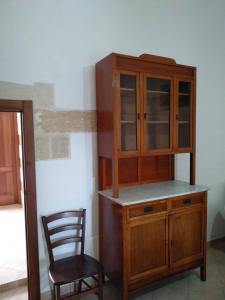 a wooden cabinet and a chair in a room at Regina Elena Casa Vacanze Salento in Santa Cesarea Terme