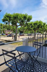 une table et des chaises assises à côté d'une clôture dans l'établissement Gîte du Vieux Lavoir, à Arnac-Pompadour