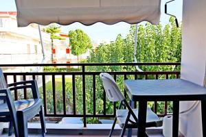 a table and two chairs on a balcony with a table and an umbrella at Το Κοράλι in Amarinthos
