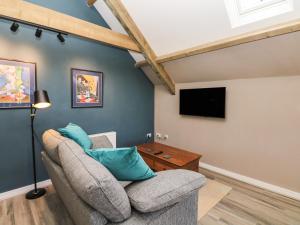 ein Wohnzimmer mit einem Sofa und einem TV in der Unterkunft Cherrywood Barn in South Petherton