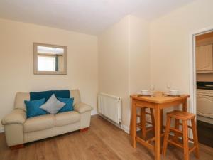 ein Wohnzimmer mit einem Sofa und einem Tisch in der Unterkunft Gardener's Cottage in Forfar