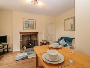 a living room with a table and a fireplace at Gardener's Cottage in Forfar