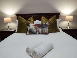 a white bed with pillows and a towel on it at Aloes Guest House 62 on Meintjies in Middelburg
