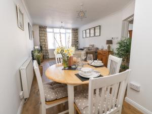 een eetkamer en een woonkamer met een tafel en stoelen bij Beach Side in Bridport