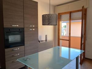 a kitchen with a glass table and a tv at Casa Selia in Cecina