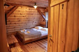 1 dormitorio con 1 cama en una cabaña de madera en Siedlisko Sodyba, en Puńsk