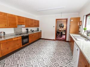 a kitchen with wooden cabinets and a tile floor at Dale View in Cockermouth