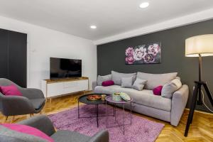 a living room with a couch and a tv at Apartment Sancti Viti in Rijeka